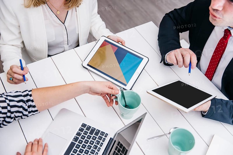 Crop businesspeople with gadgets desk