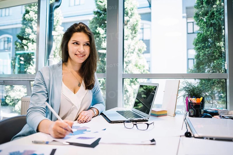 Smiling dreamy woman with papers