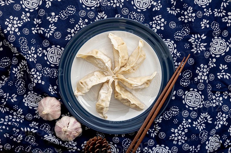Dim sum white plate with garlic floral blue background