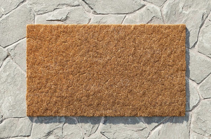 Overhead of blank doormat on the rock tile porch