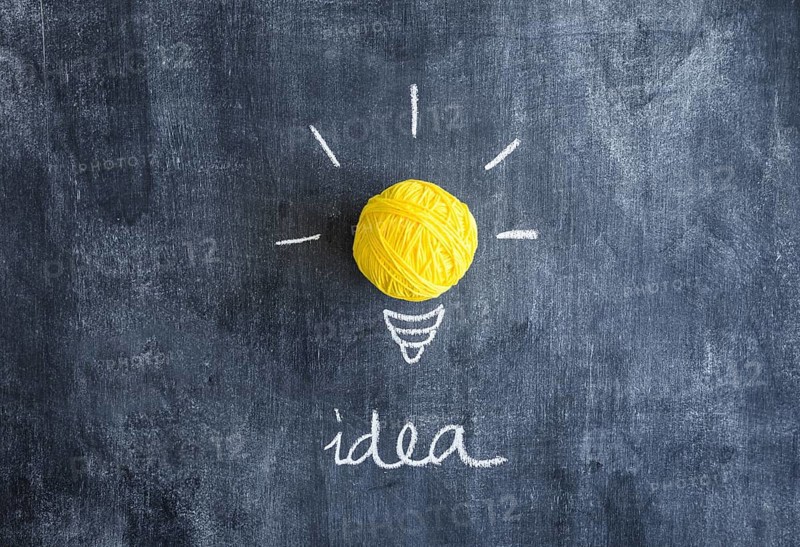Ball yellow yarn with idea text chalkboard