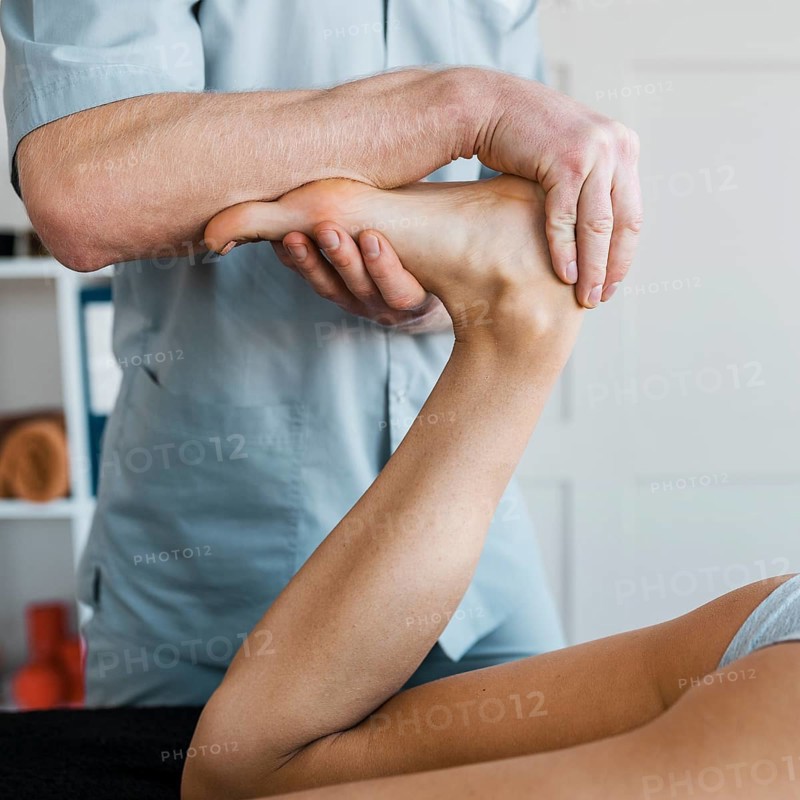 Male physiotherapist female patient during massage session