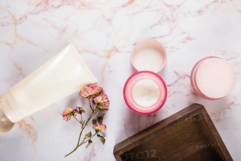 Moisturizing cream with flowers marble background