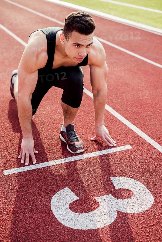 Muscular male young runner start line