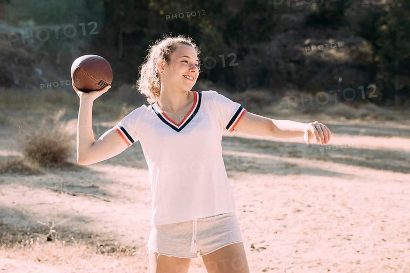 Cheerful teen schoolgirl playing rugby