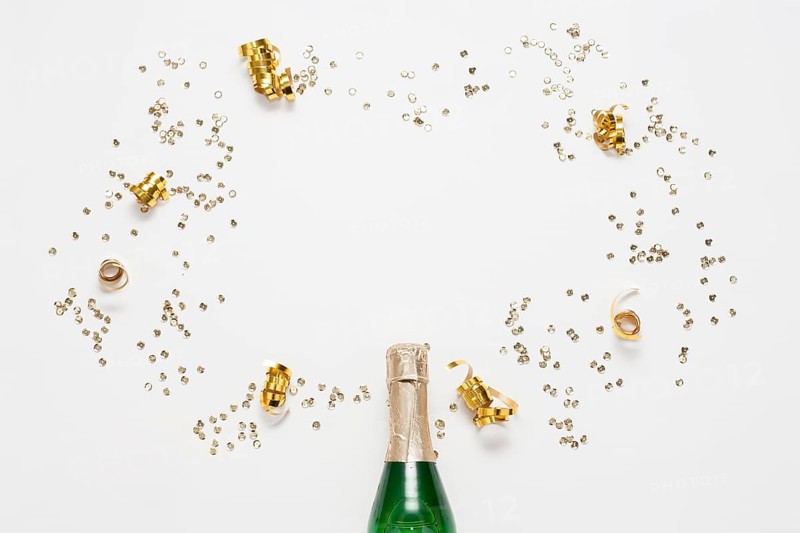 Top view champagne bottle with golden ribbons confetti