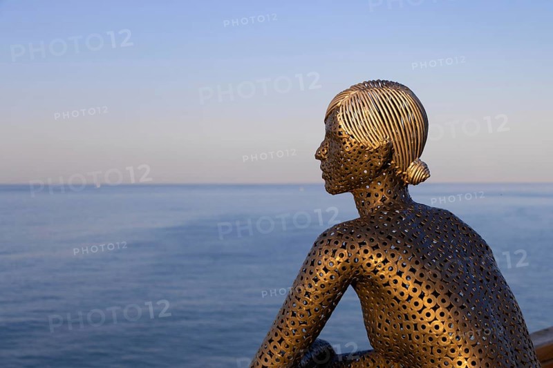 A metal sculpture by artist Carlos de Oliveira Correia looks out over the Atlantic Ocean from the viewing platform on Olhos des Augua beach shortly after sunrise.