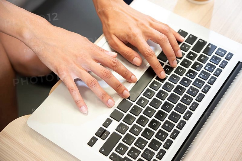 Hand typing laptop top view