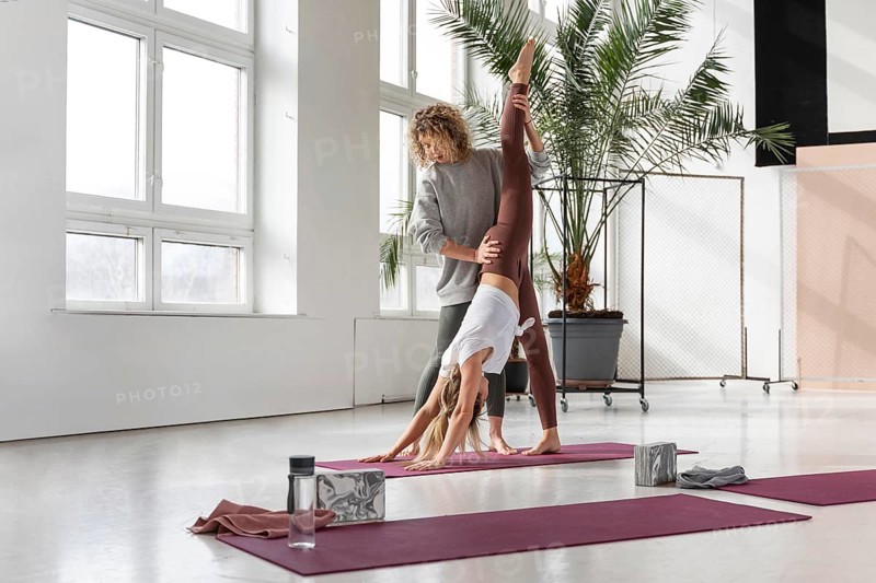 Yoga teacher helping woman 3