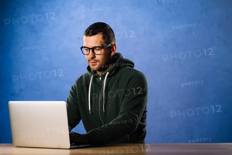Hacker with glasses looking laptop