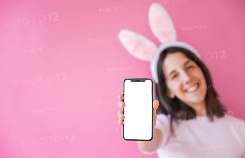 Woman bunny ears holding smartphone with blank screen