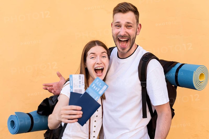 Side view smiley tourist couple with plane tickets passports