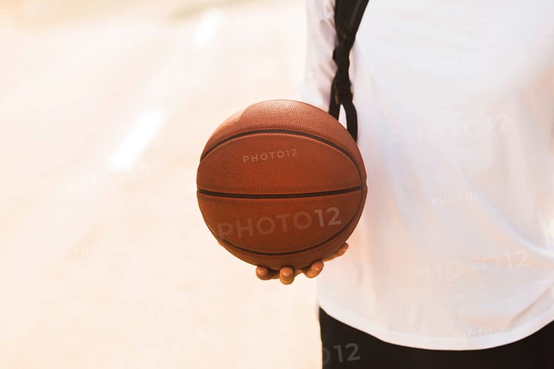 Unrecognisable man holding basketball front view