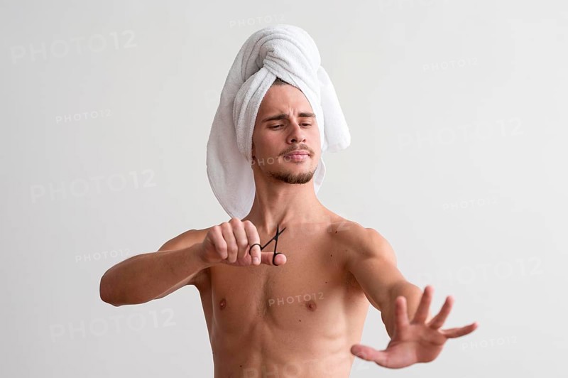 Front view shirtless man with towel his head looking his fingernails