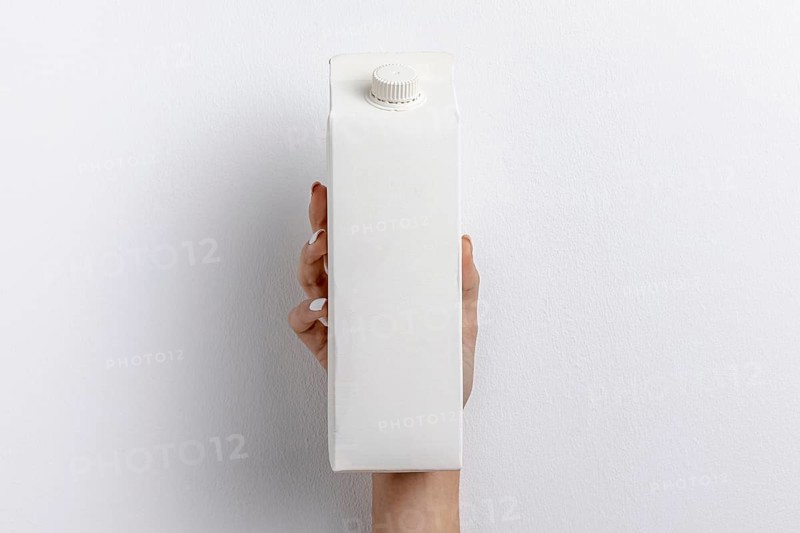 Front view hand holding simple milk carton