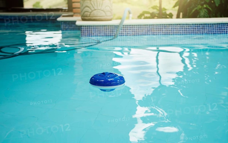 Chlorine dispenser in a beautiful swimming pool. A chlorine float in a swimming pool. Dosing float for swimming pool chlorination