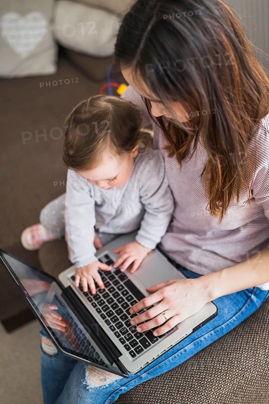 Overhead view mother sitting with her child using laptop