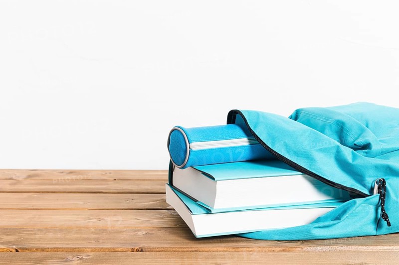 Blue books pencils case opening schoolbag wooden table