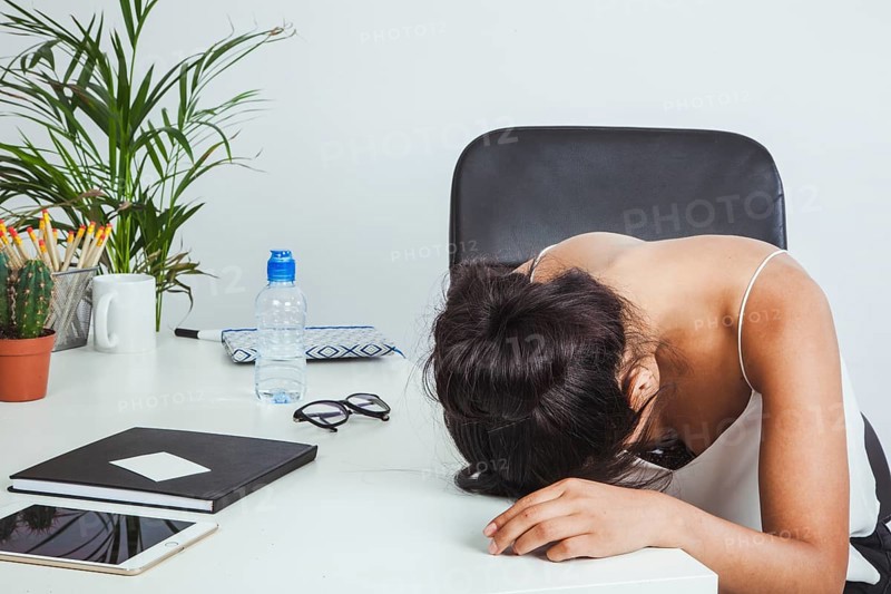 Tired businesswoman laying her head table