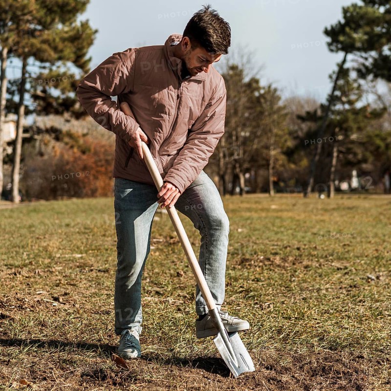Man using shovel dig hole planting tree