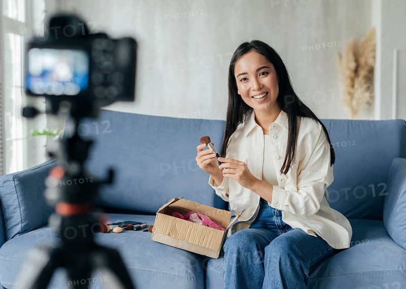 Woman live streaming home with make up tools