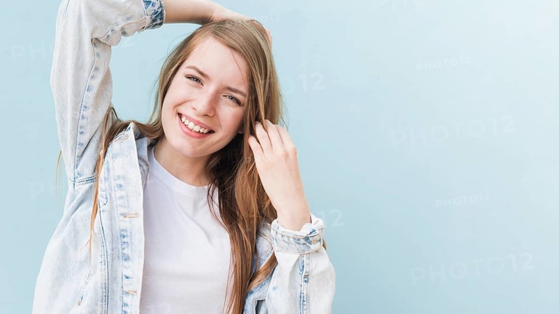 Portrait smiling attractive woman blue wall