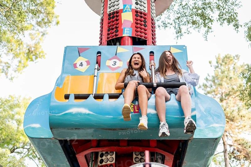 Smiley female friends having fun amusement park