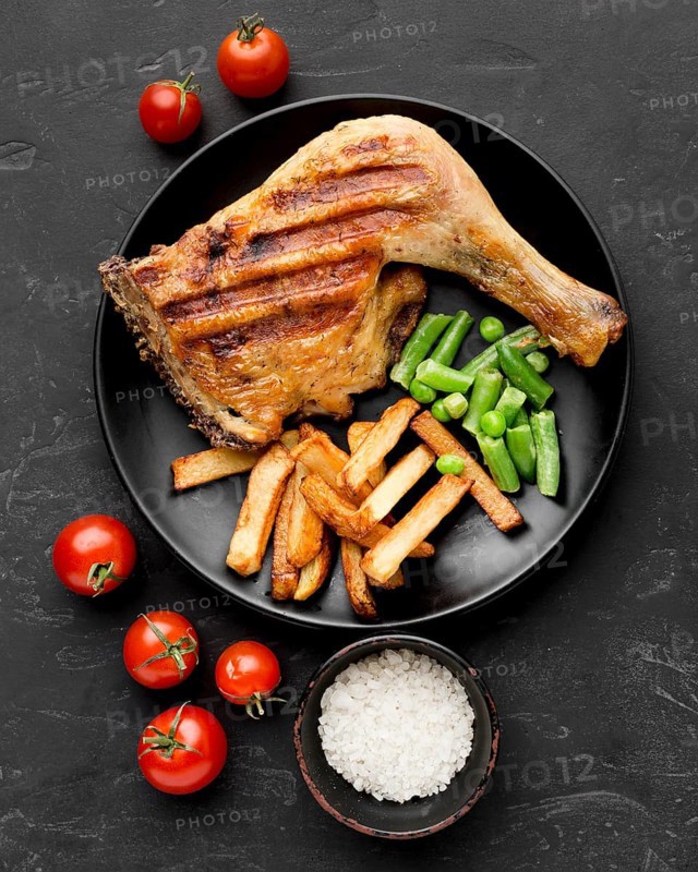 Top view baked chicken potatoes plate with tomatoes