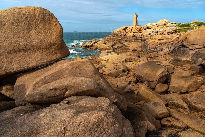 The rocks of the pink granite coast Cote de Granit Rose and the lighthouse Phare de Ploumanac'h near Ploumanac'h