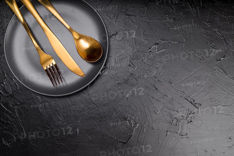 Top view plate with golden cutlery copy space