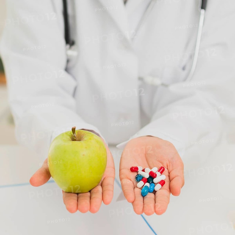 Doctor holding green apple pills