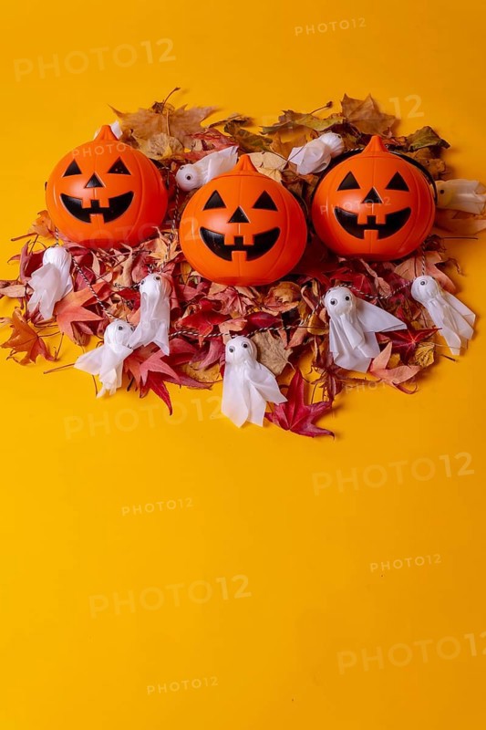 Overhead view of orange Halloween pumpkins on a background of yellow