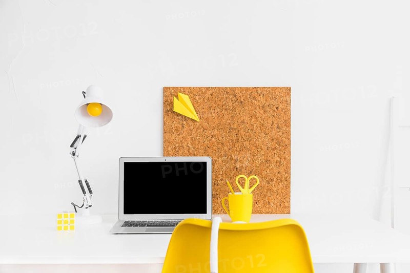 Stylish workspace yellow white colors with cork board