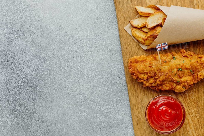 Top view fish chips paper wrap with ketchup copy space