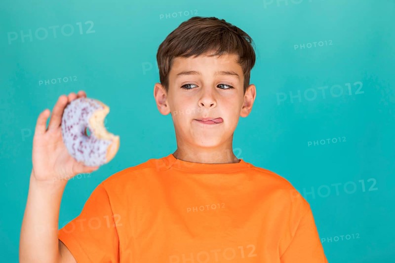 Boy looking delicious glazed doughnut
