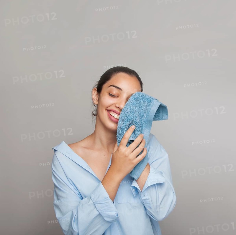 Happy woman cleaning her face morning