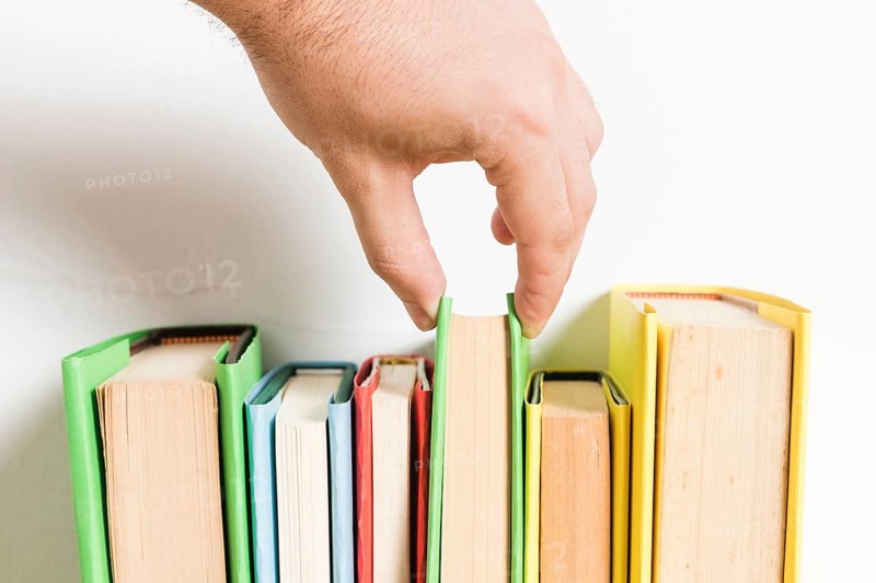 Person choosing book from shelf