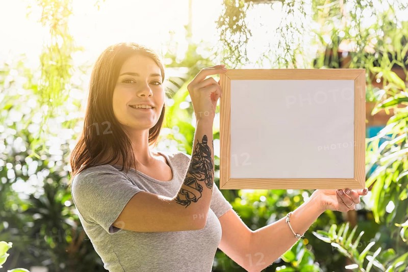 Attractive happy woman holding frame plants