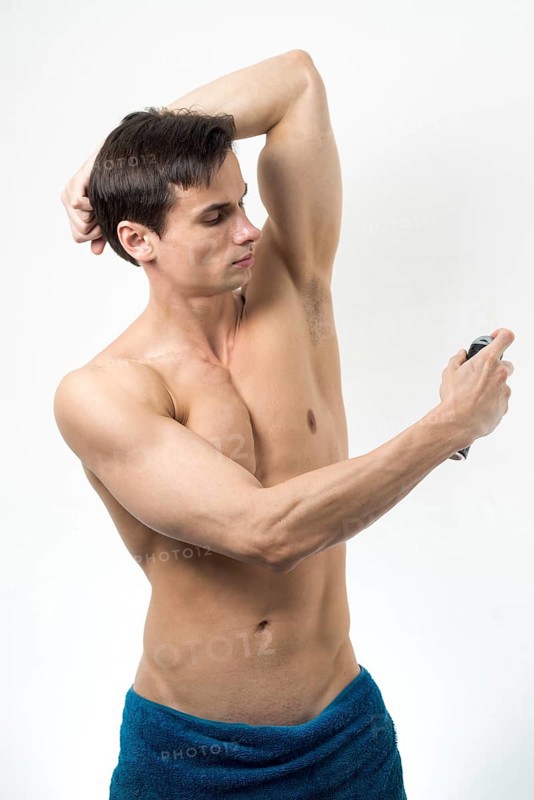 Medium shot man applying deodorant