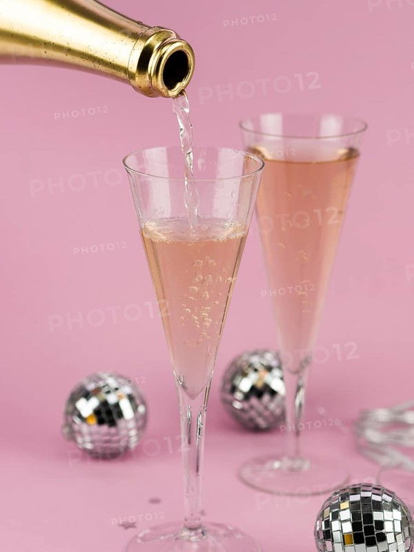Champagne pouring glass from golden bottle