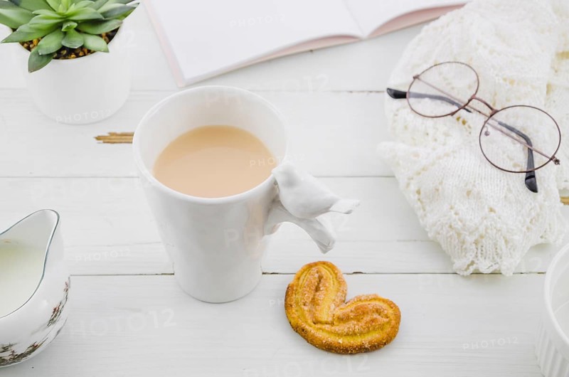 Palmiers elephant ear puff pastry cookie with porcelain white tea cup wooden desk