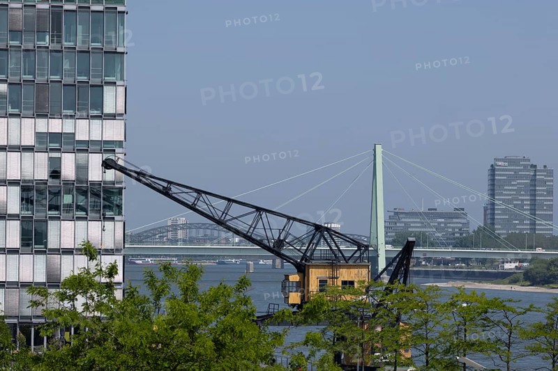 Old cargo crane in Cologne's Rheinauhafen in front of the Rhine and Severinsbruecke