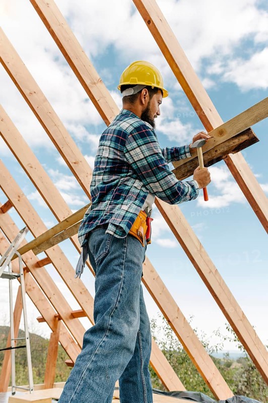 Construction worker with hard hat building roof house