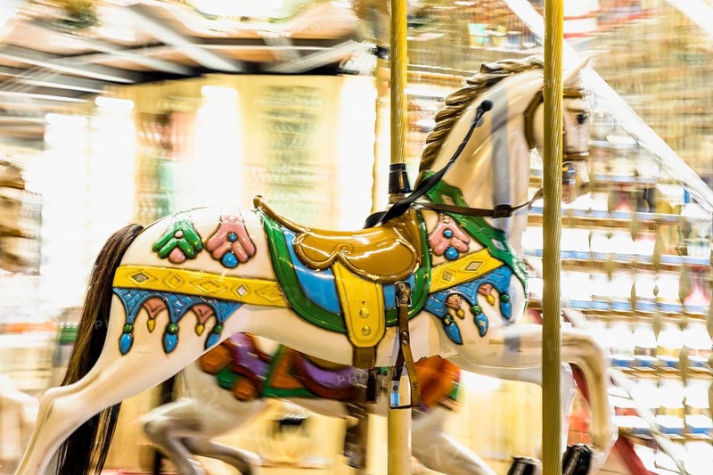 Nostalgic horse detail carousel spinning with light blurs night