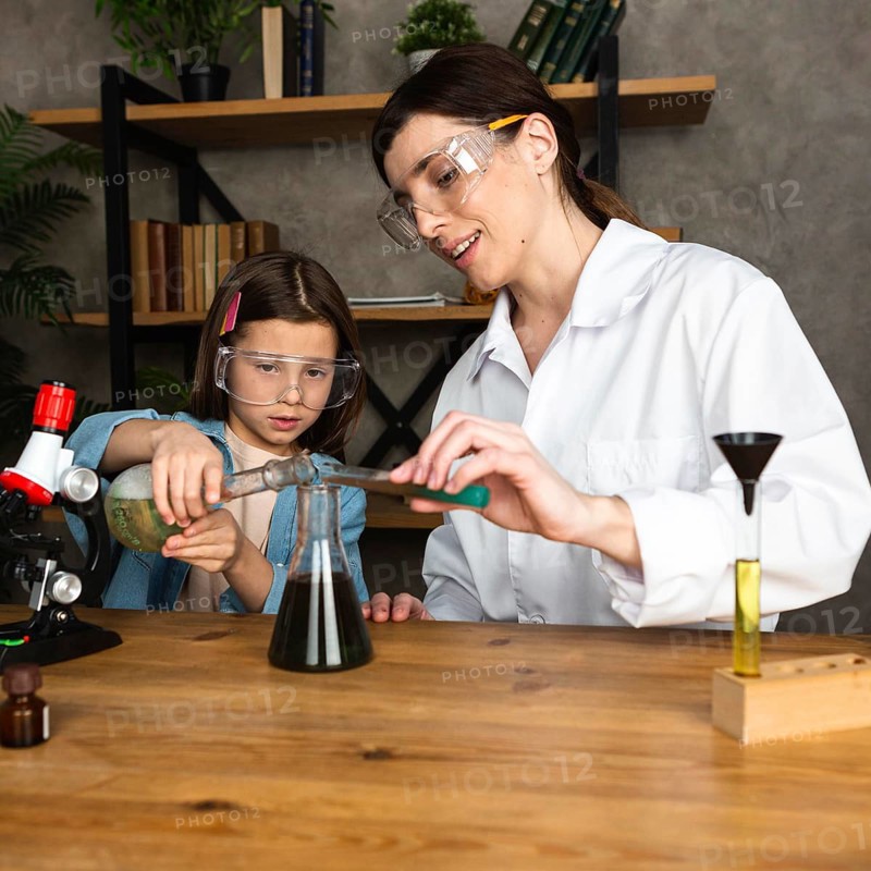 Girl female teacher doing science experiments with microscope