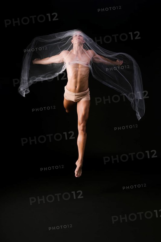 Naked gymnast jumping with transparent cloth