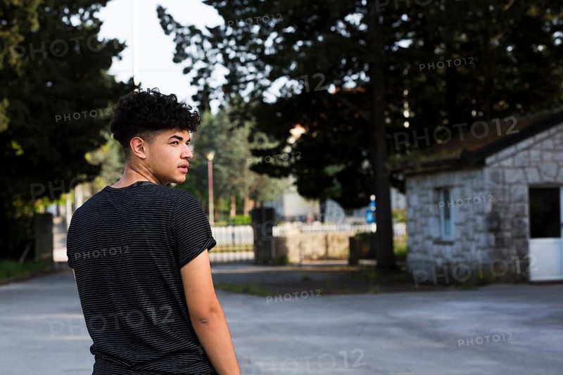 Young man looking back urban environment