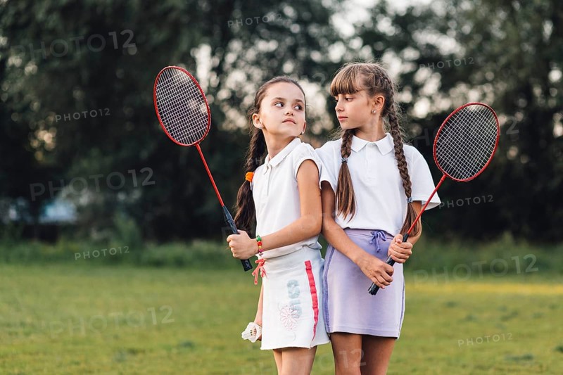 Angry girls holding badminton hand looking each other