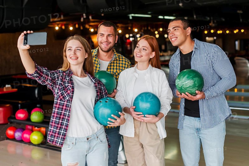 Friends holding colorful bowling balls