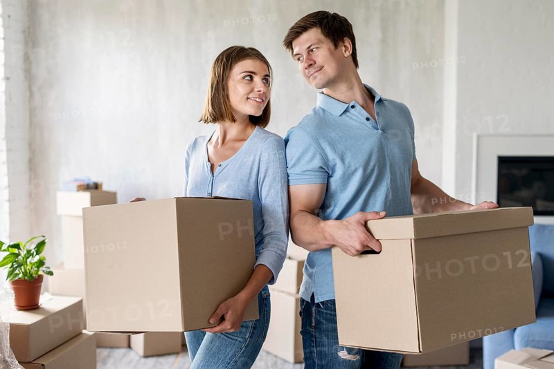 Couple holding boxes moving out day